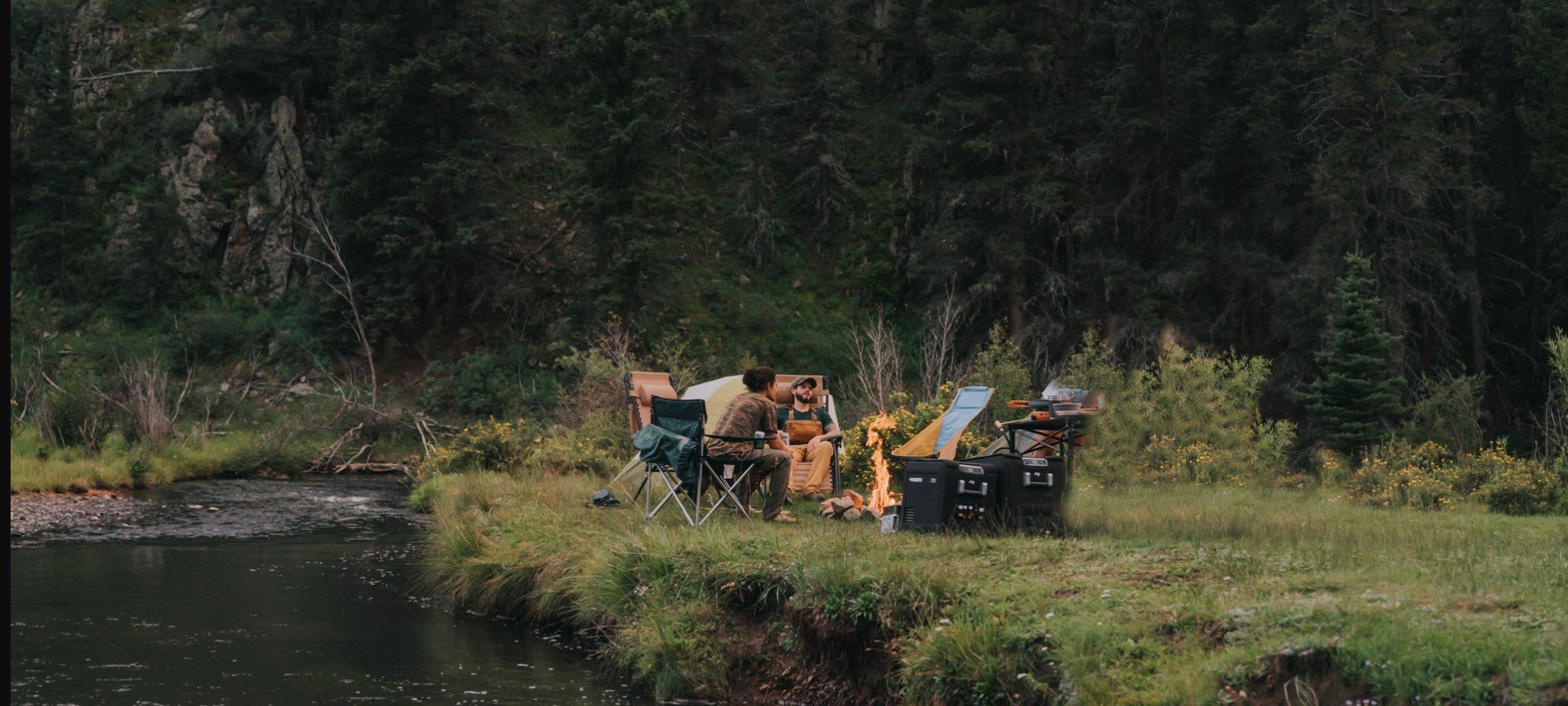 Campers enjoying camp in the forest by the river