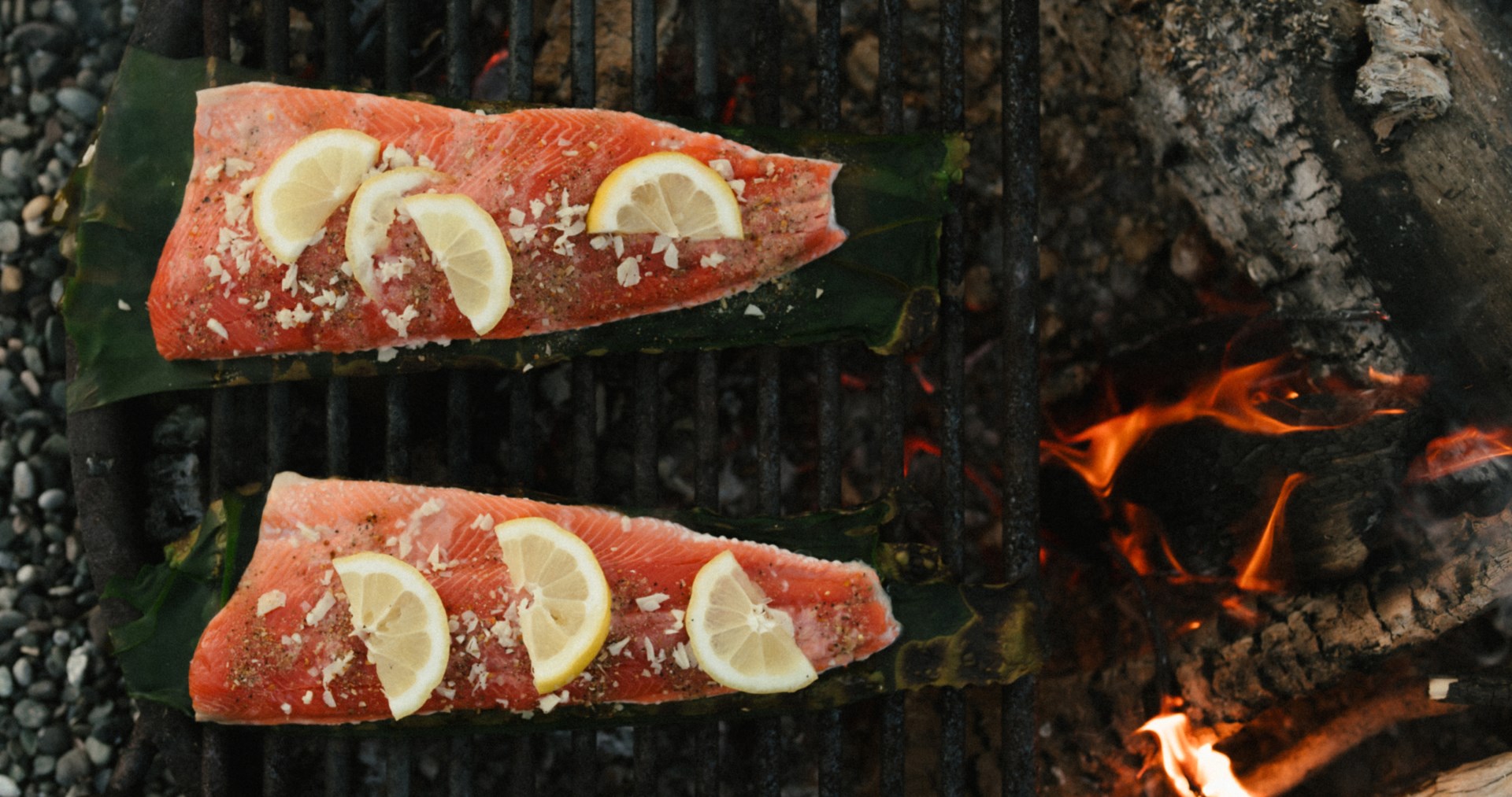 Salmon with lemon cooking on open fire.