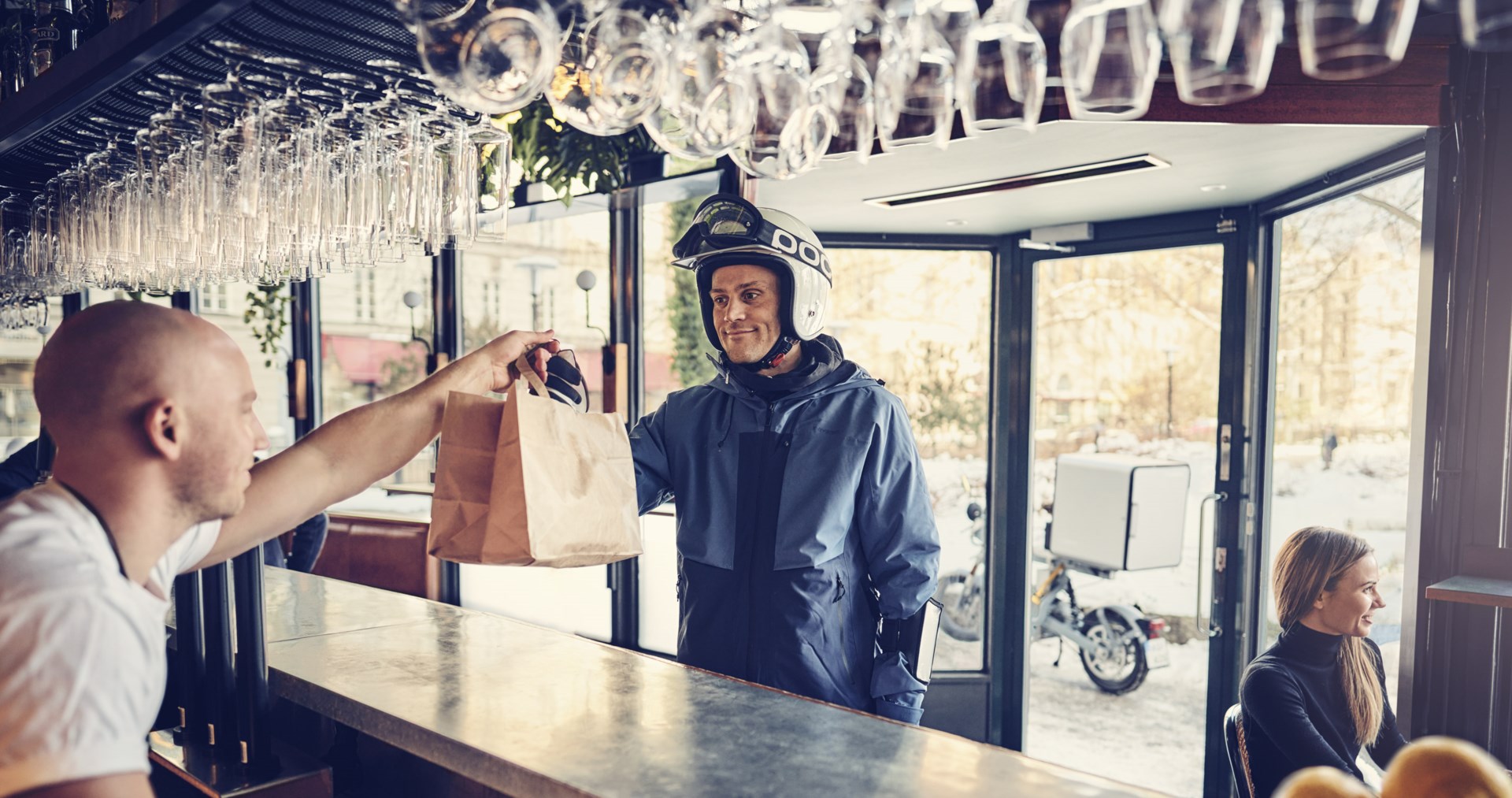 Food delivery driver being given an order at a restaurant to deliver