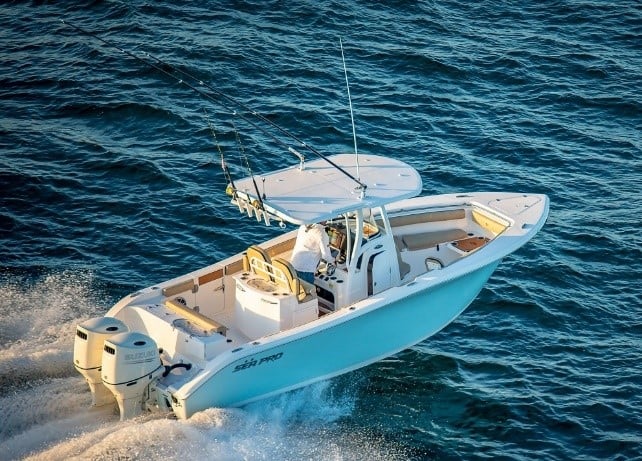 A birds eye view of a boat driving in the middle of the ocean.