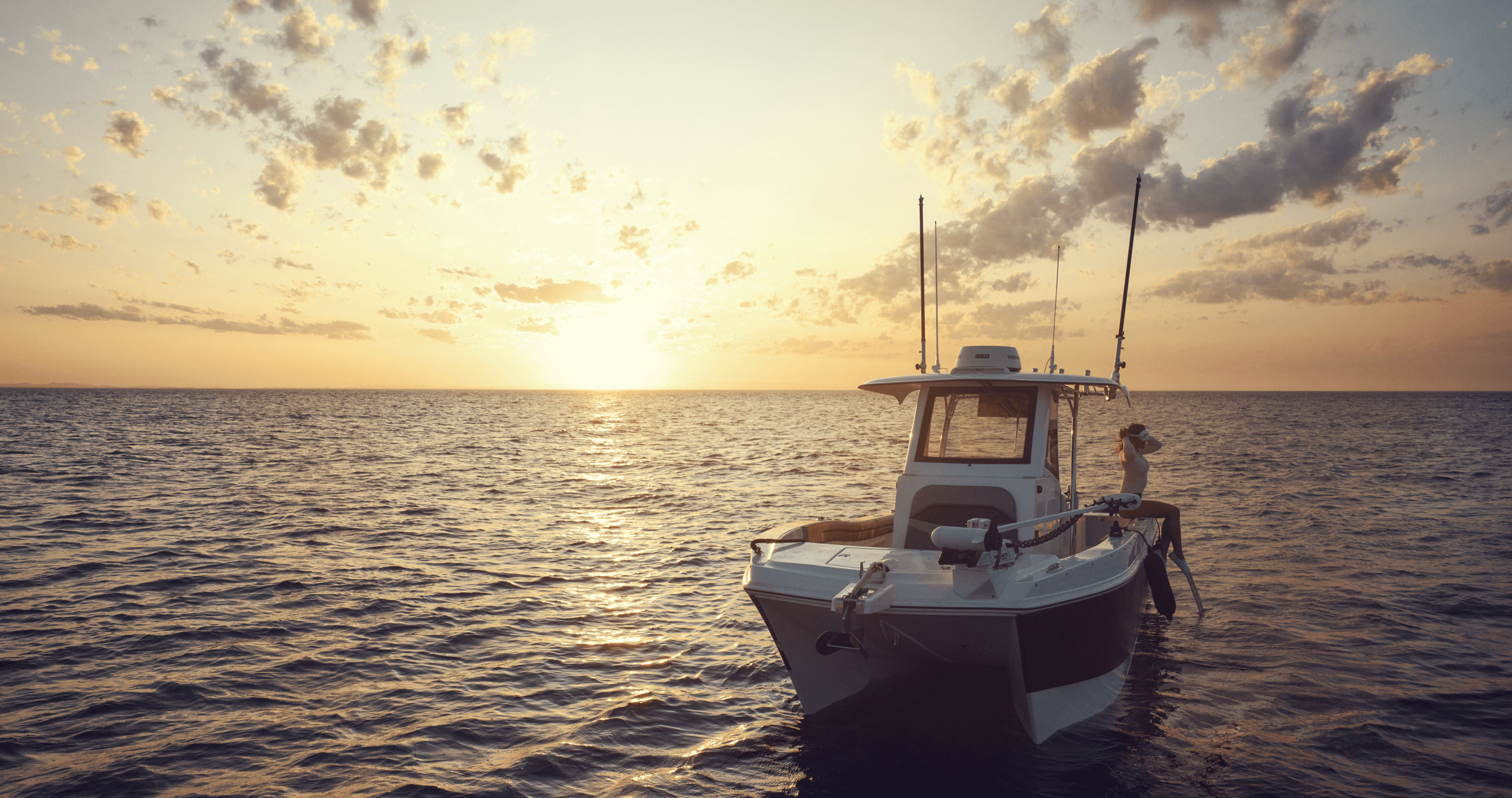 Person sitting on the side of a boat in snorkeling gear