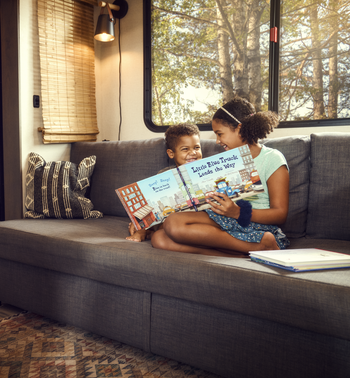 children sitting on couch inside air conditioned RV