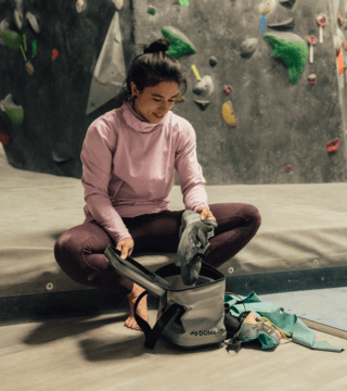 Woman indoor rock climbing with Dometic storage bag