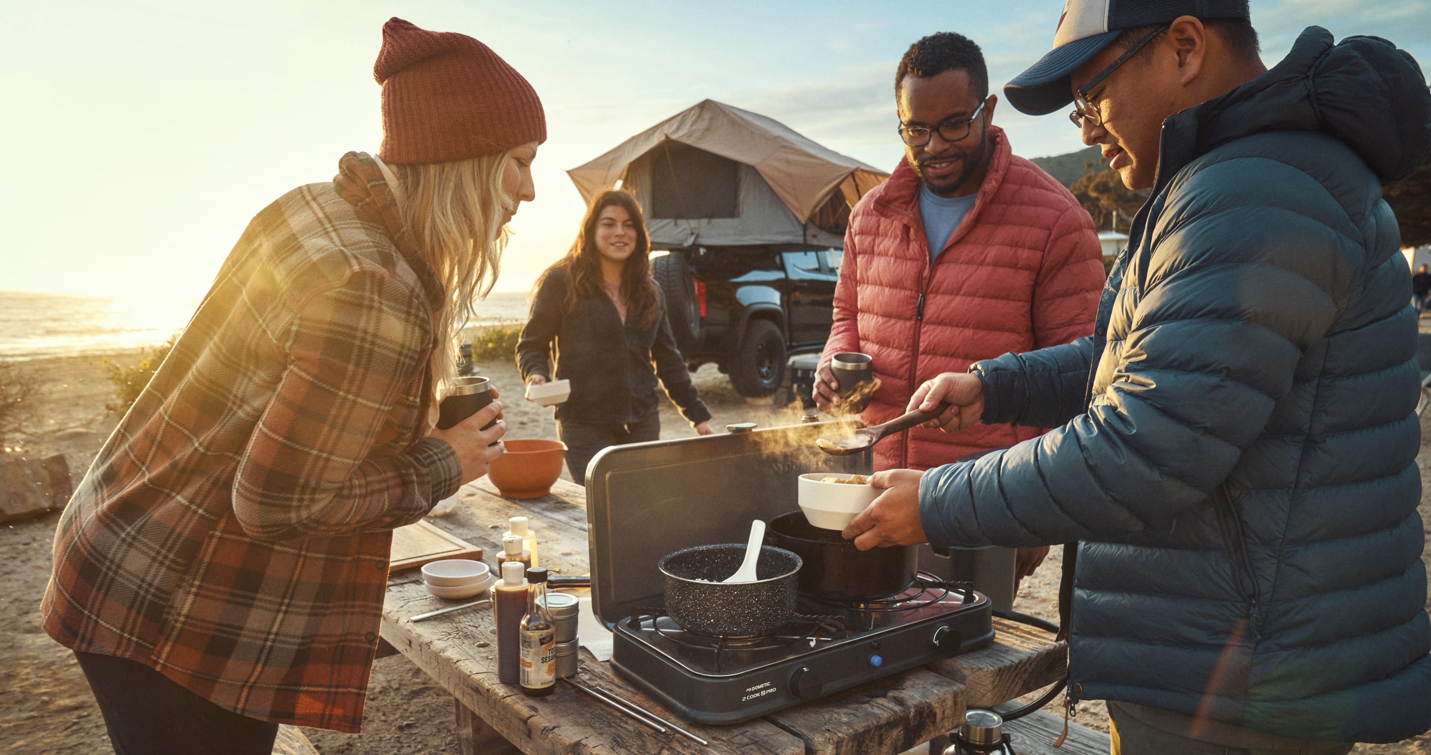 Family cooking outdoors with Dometic Water Jug