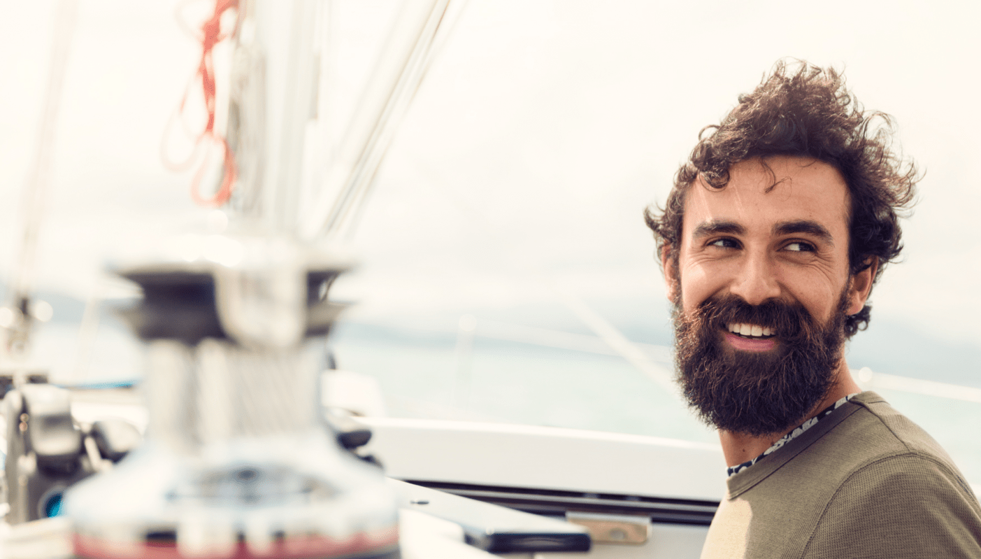 Man with windswept hair standing on a boat