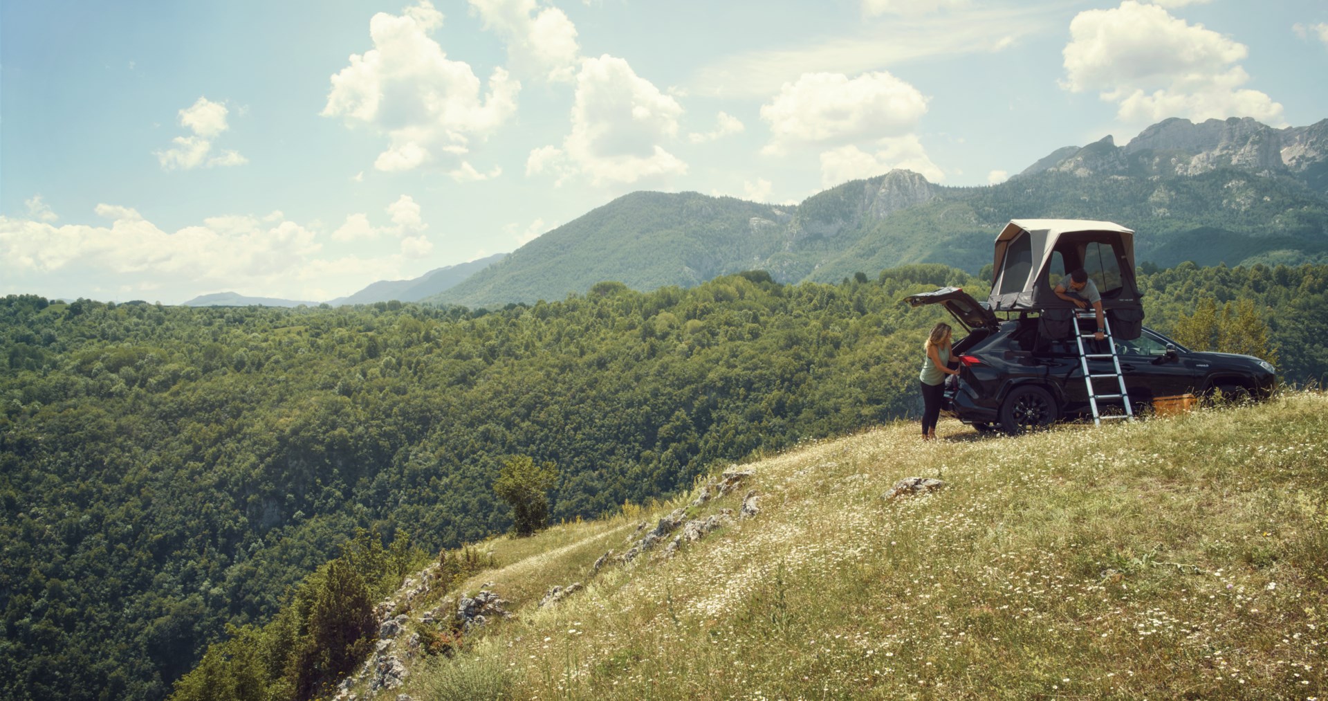 Car with rooftop tent on a hill