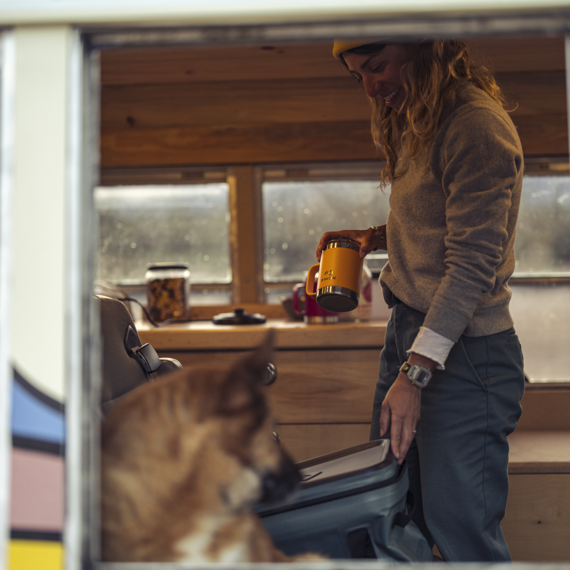 woman pulling cup out of soft storage while camping
