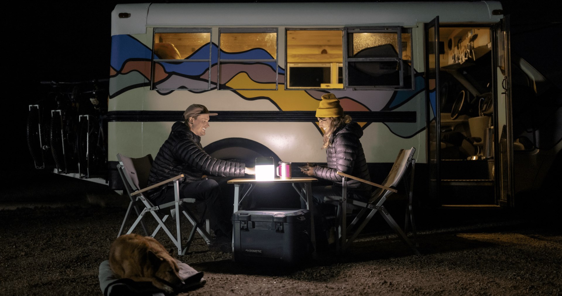 couple sitting outside while off-grid camping at night