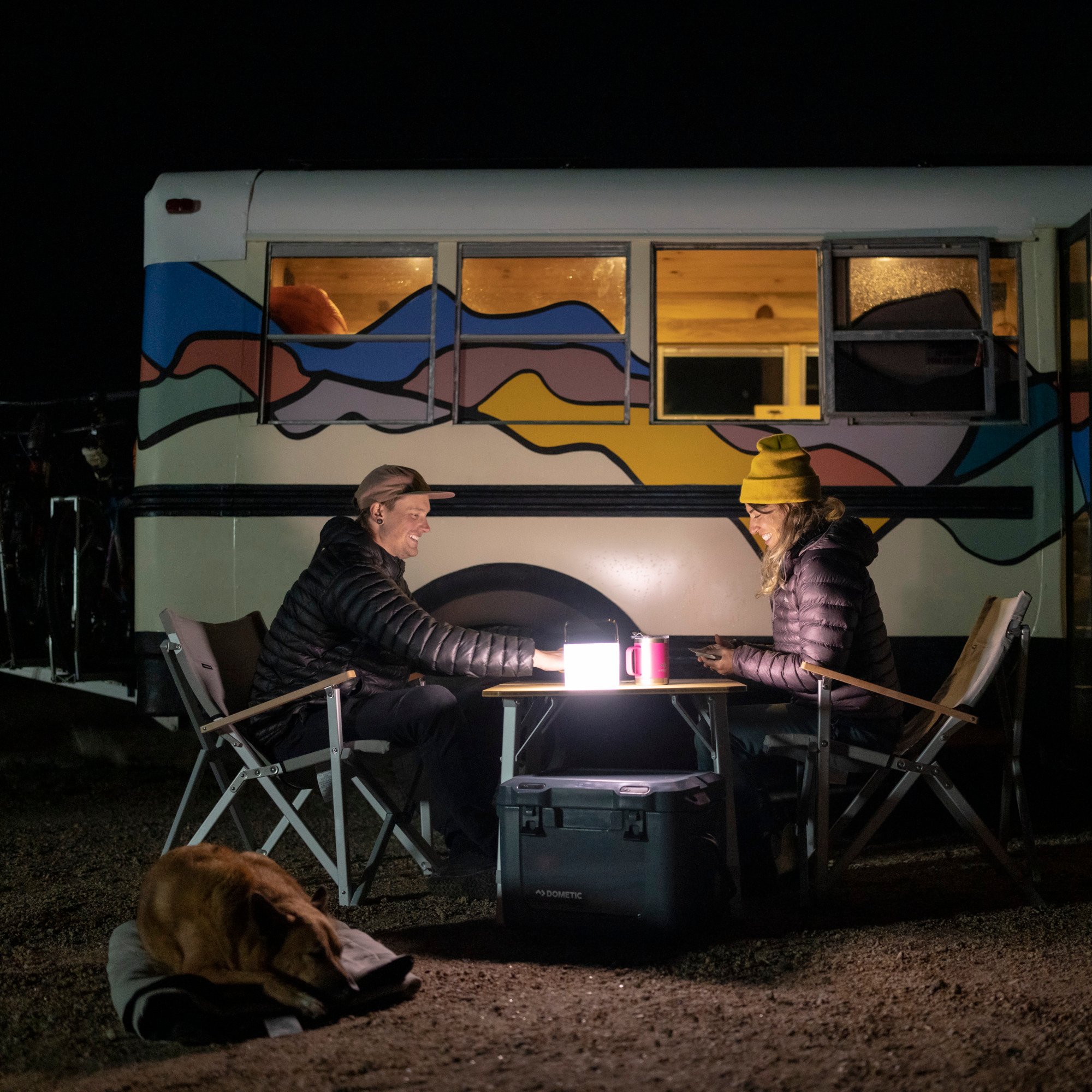 couple sitting outside at night while camping