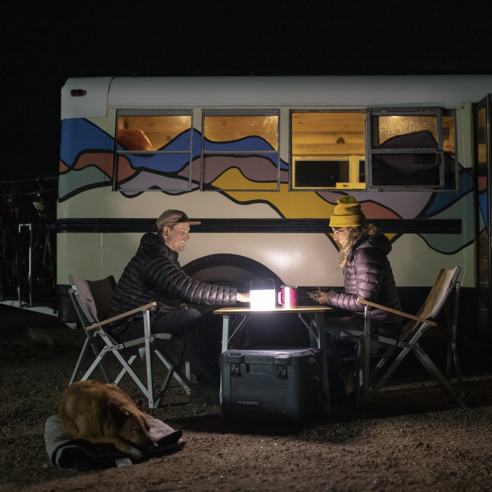 couple sitting outside camping at night