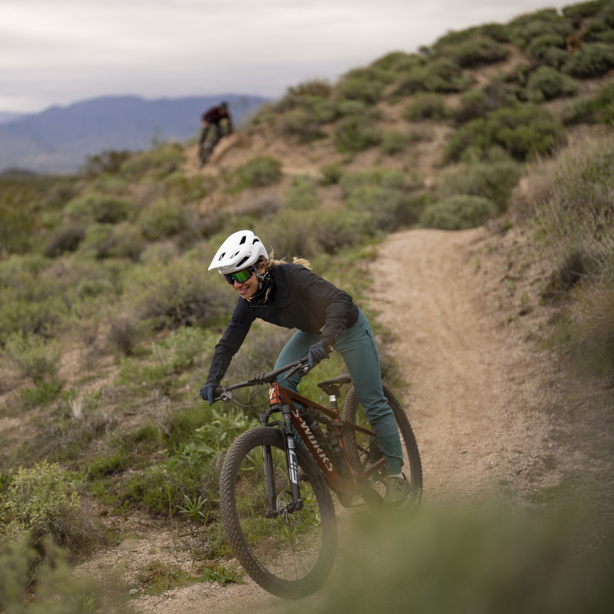 woman mountain biking on trail